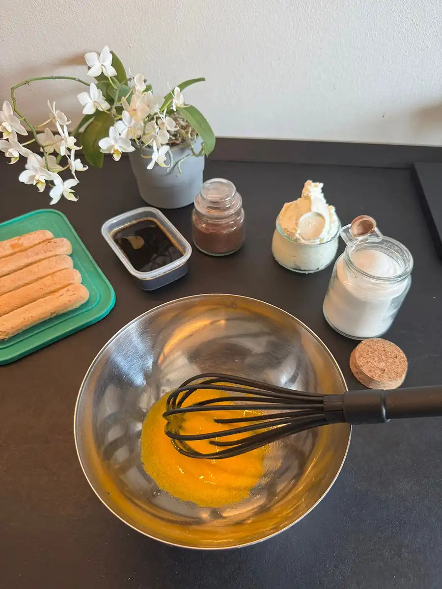 Uovo sbattuto insieme allo zucchero in una ciotola.